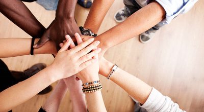 Diverse group of people putting their hands in together